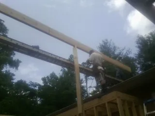 Carpenter setting a ridge beam over a new addition frame — Ice Dam Removal by Roofing Brothers in Plattsburgh