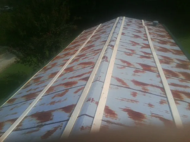 Rusted metal roof panels with new wood purlins before replacement — Storm Damage Roof Repair in Plattsburgh by Roofing Brothers