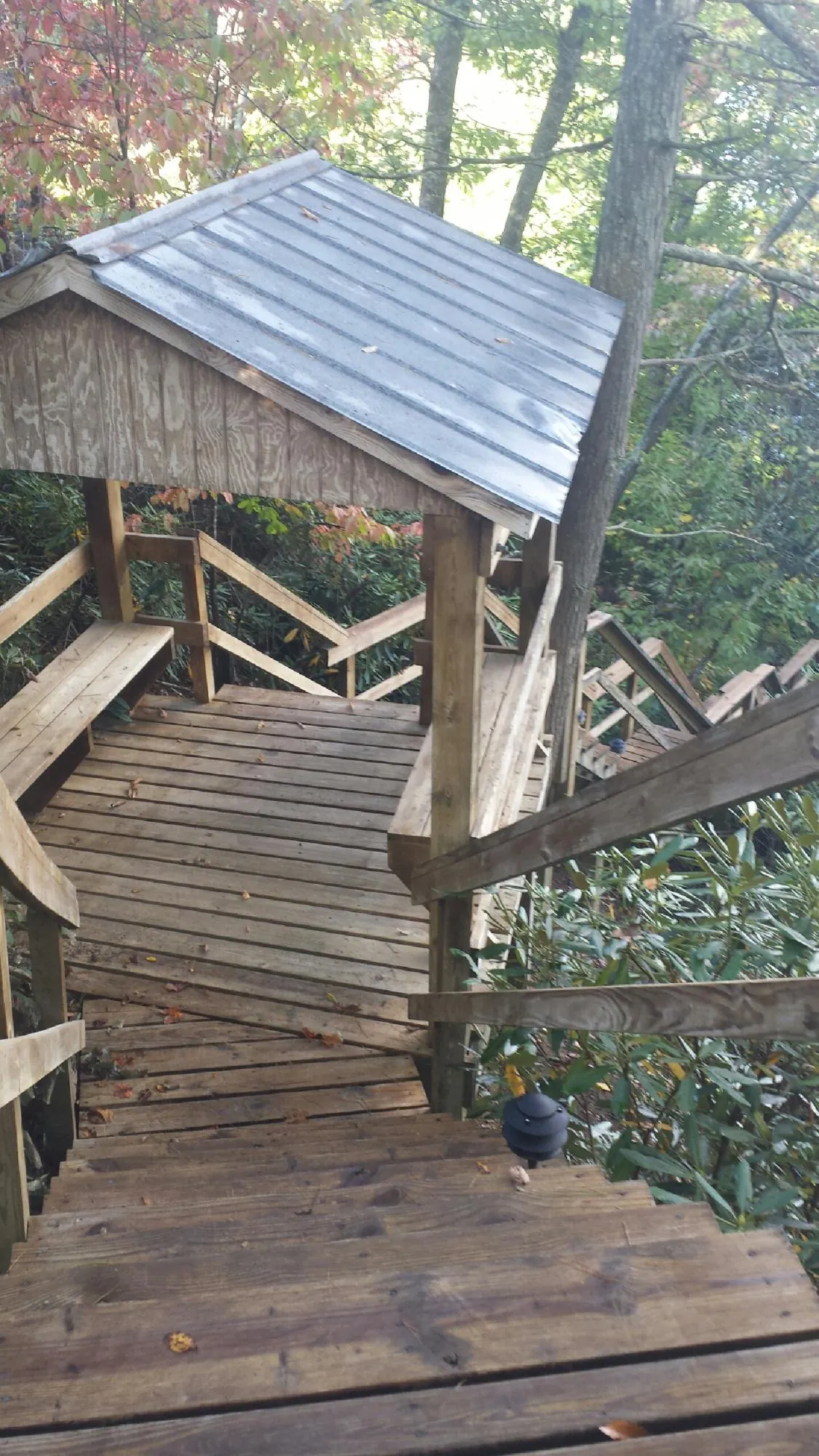 Metal roofed shelter over wooden steps on a wooded walkway — Skylight Repair & Installation work by our crew in Plattsburgh