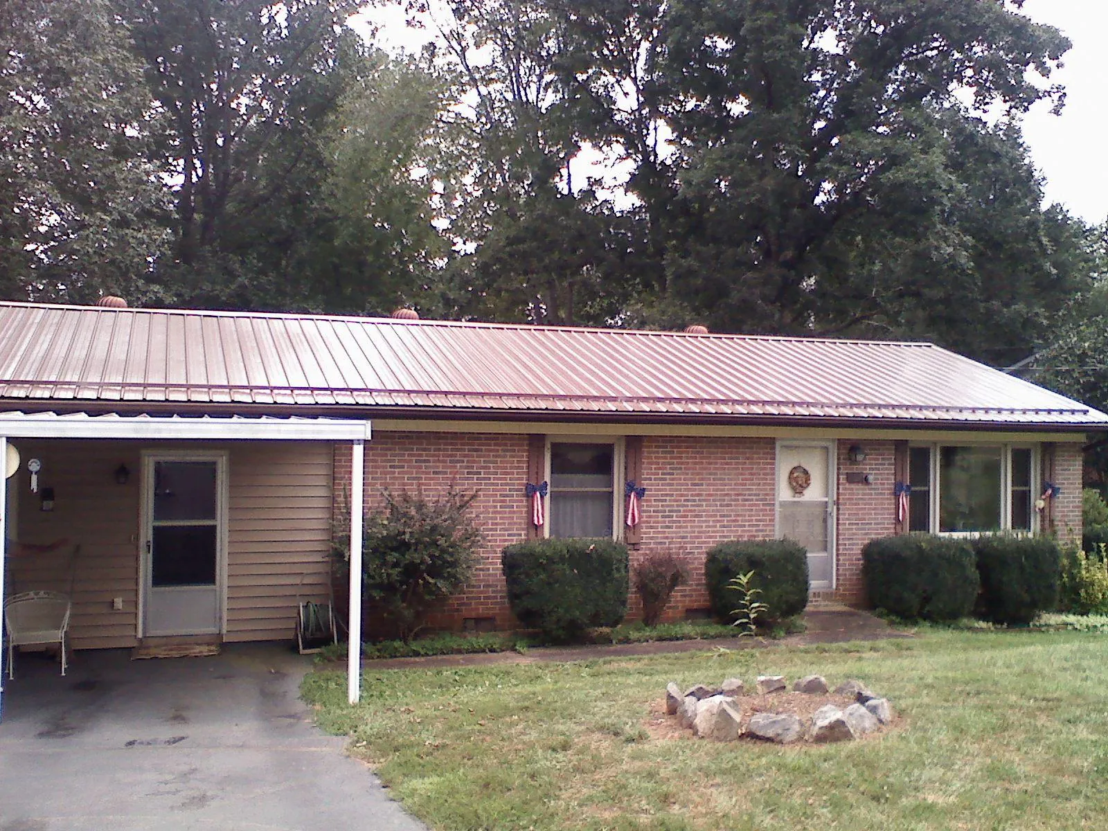 Bronze metal roof and carport on a brick ranch home — Roof Repair work by our crew in Plattsburgh